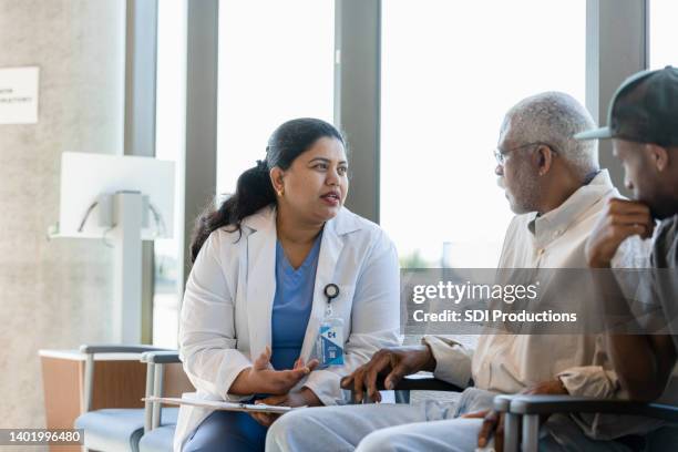 medico donna compassionevole discute problemi medici con paziente anziano - rapporto medico paziente foto e immagini stock