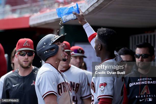 Geraldo Perdomo of the Arizona Diamondbacks dumps sunflower seeds on Josh Rojas after Rojas scored a run in the ninth inning against the Cincinnati...