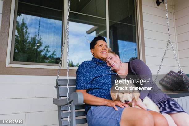 lesbian couple on front porch swing - swing chair stock pictures, royalty-free photos & images