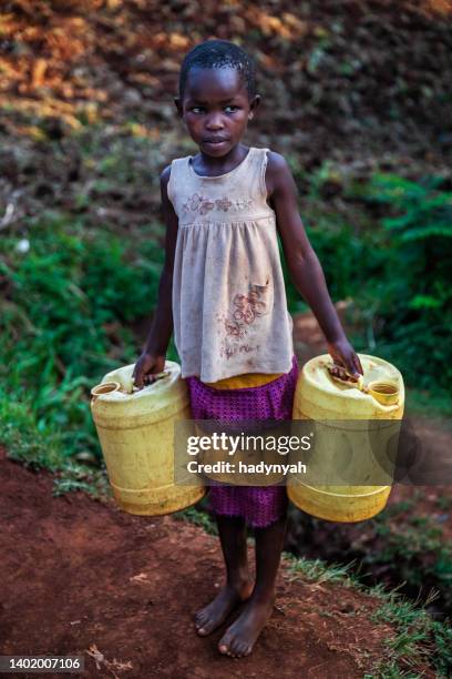 african little girl carrying water from the well, kenya, east africa - trabalho infantil imagens e fotografias de stock