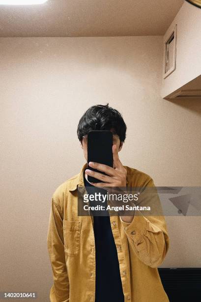 man taking a selfie on mirror hiding his face - autorretratarse fotografías e imágenes de stock