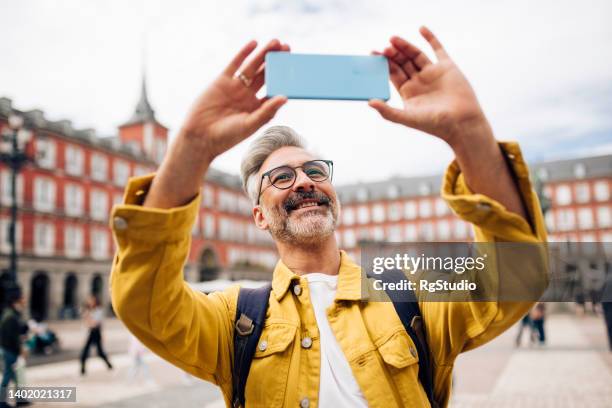 mature man on vacation sightseeing and photographing - turista imagens e fotografias de stock