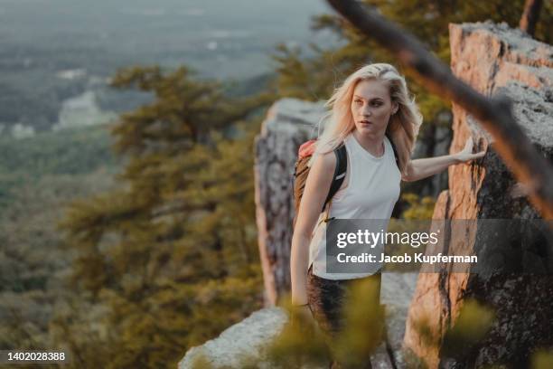 young female hiker on a trail at sunset - pedestrian walkway stock-fotos und bilder