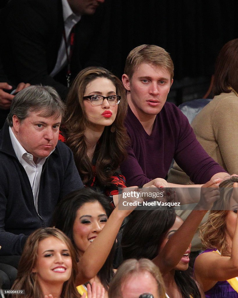 Emmy Rossum and Tyler Jacob Moore attend a basketball game between