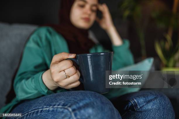 finding comfort in a cup of coffee or tea while experiencing a headache - burka stock pictures, royalty-free photos & images