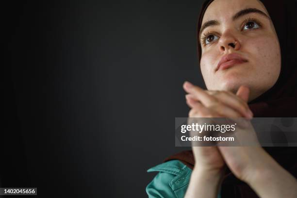 copy space shot of worried young woman sitting with hands clasped, pondering - burka stock pictures, royalty-free photos & images