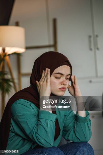 battling anxiety and negative thoughts, causing a painful migraine - burka stock pictures, royalty-free photos & images
