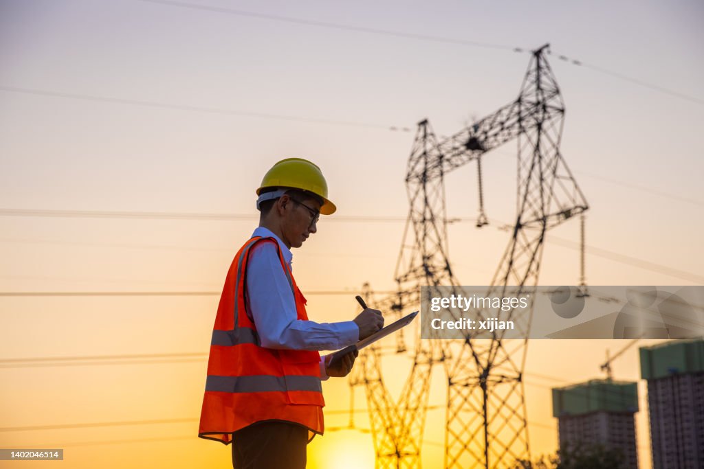Engineer working by high voltage tower