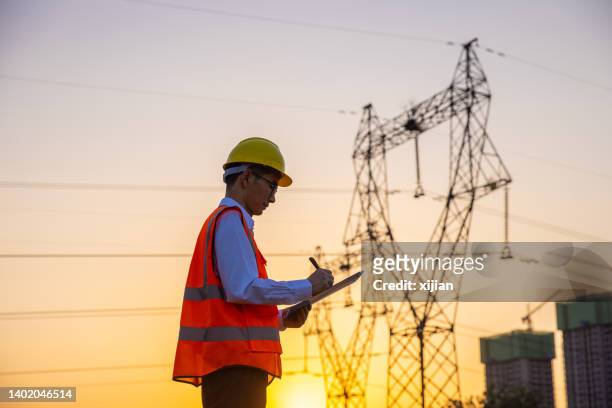 engineer working by high voltage tower - communications tower 個照片及圖片檔