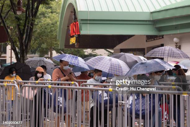 Visitors wait in line to enter a store at Shanghai Disney Resort on June 10, 2022 in Shanghai, China. Shanghai Disney Resort is resuming partial...