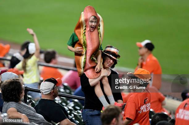 Fan dressed in a hot dog costume cheers during the game between the Baltimore Orioles and the Cleveland Guardians at Oriole Park at Camden Yards on...