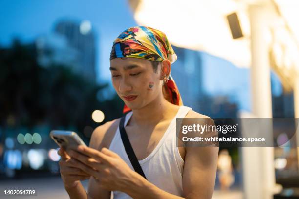 jóvenes lgbtq asiáticos usando el teléfono inteligente con alegría. - estilo de vida alternativo fotografías e imágenes de stock