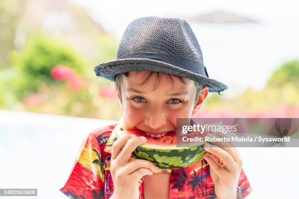 beautiful child with straw hat eating watermelon - melone hut stock-fotos und bilder