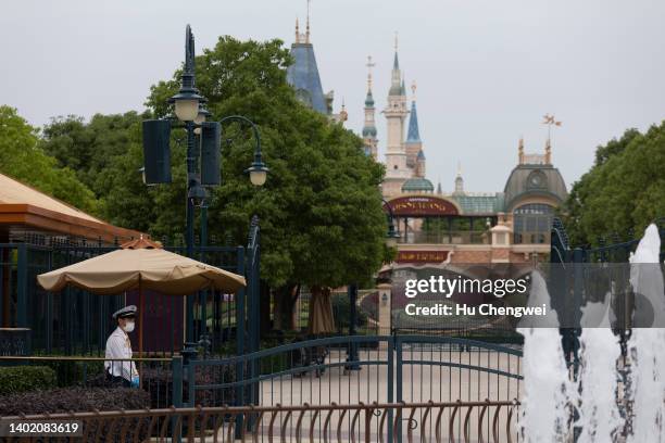 Resort staff stands on patrol behind a closed section of Disneyland at Shanghai Disney Resort on June 10, 2022 in Shanghai, China. Shanghai Disney...