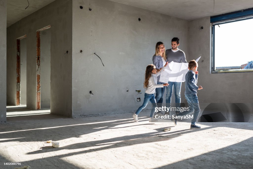 Happy family analyzing plans at their new apartment
