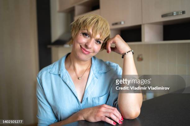 a content transitioning woman smiling at the camera - non binary stereotypes stock pictures, royalty-free photos & images