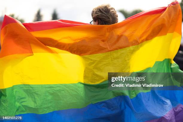 stolz die große pride-flagge hochhalten - regenbogenfahne stock-fotos und bilder