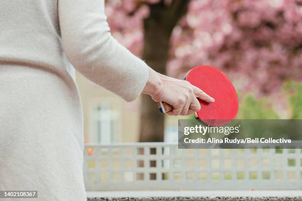 senior woman holding a table tennis racket - women's table tennis stockfoto's en -beelden