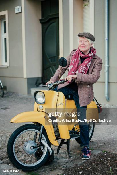 senior woman on a motor scooter - moped stock-fotos und bilder