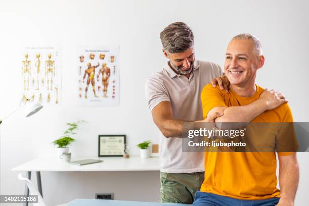 modern rehabilitation physiotherapy worker with male client - 物理療法 個照片及圖片檔