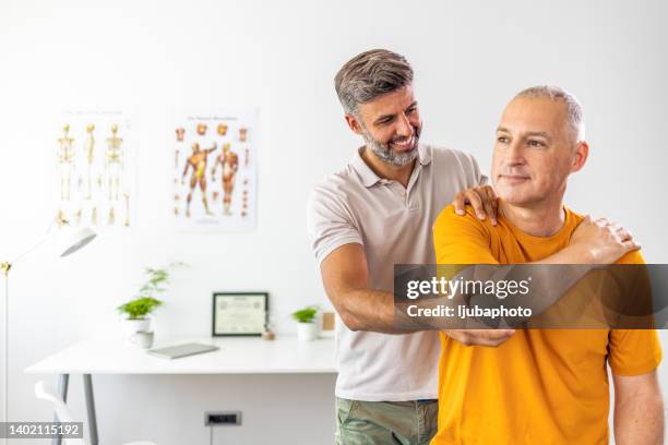 uomo con regolazione della schiena chiropratica - alternative therapy foto e immagini stock