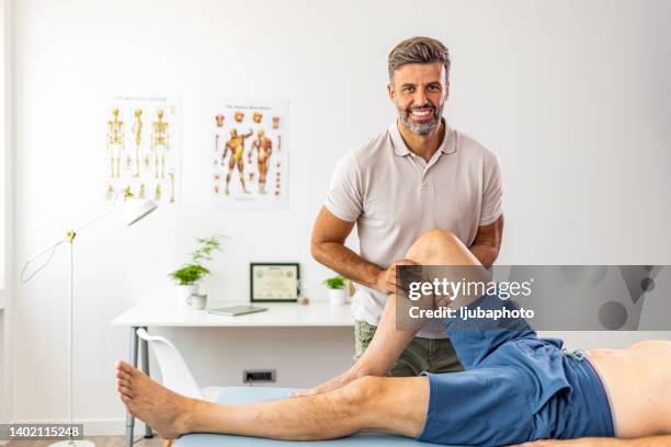 doctor giving a patient a leg treatment - chiropractic treatment stock pictures, royalty-free photos & images