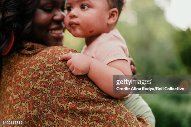 mother holding her baby - showus stock pictures, royalty-free photos & images