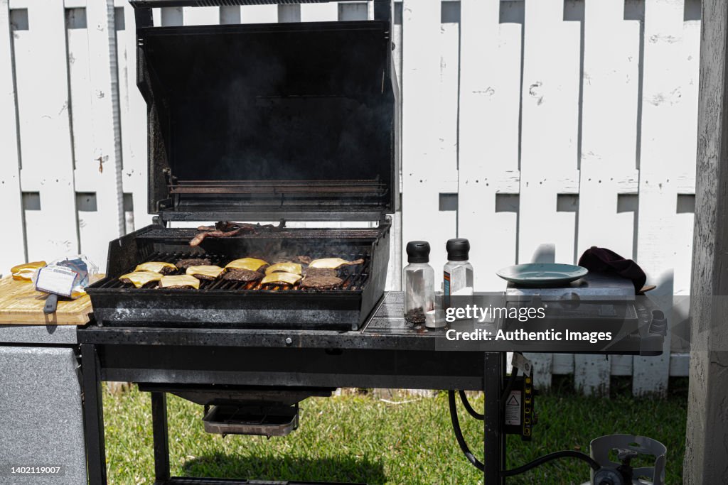 Barbecue full of hamburguer and cheesebuguers grilling