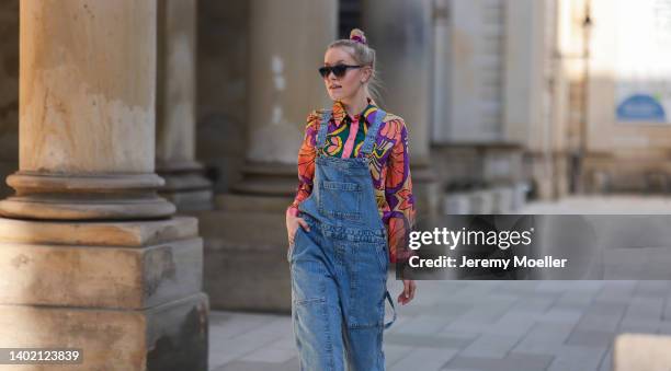 Lil Paulin seen wearing a black sunglasses, a colorful shirt blouse and a dark blue denim dungarees/jumpsuit on June 09, 2022 in Hamburg, Germany.