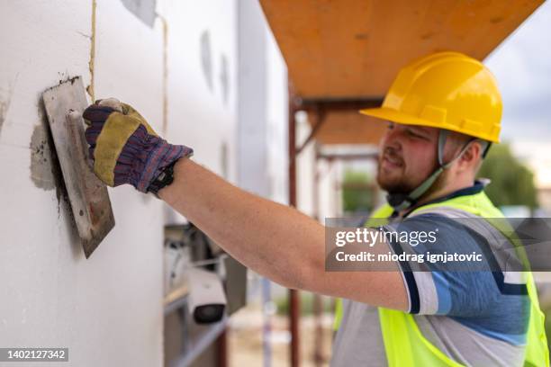 male construction worker, working on a scaffolding - plasterer stock pictures, royalty-free photos & images