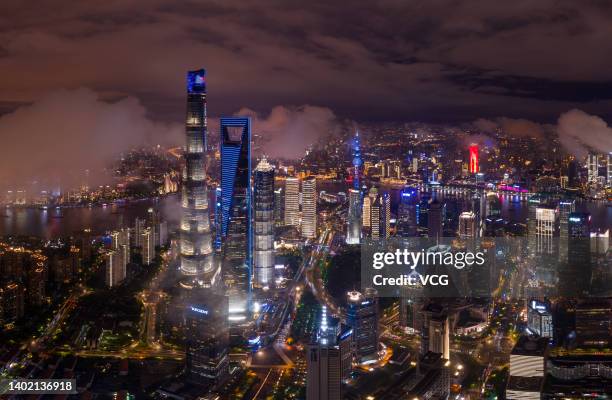 Aerial view of illuminated skyscrapers standing at the Pudong Lujiazui Financial District at night on June 10, 2022 in Shanghai, China.