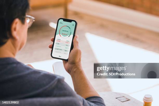 senior man checks finances on banking app - bank statement bildbanksfoton och bilder