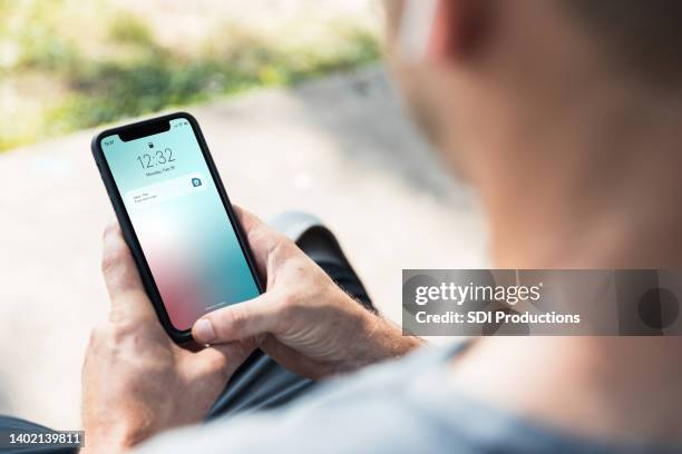 man checks his home's security - smartphone screen stockfoto's en -beelden