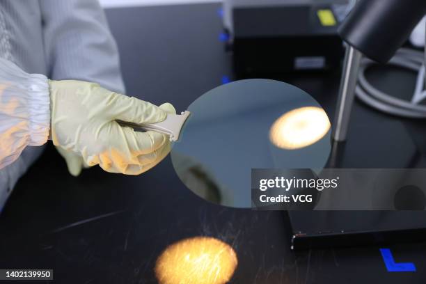 An employee works on the production line of silicon carbide wafer at a factory on May 31, 2022 in Dongying, Shandong Province of China.