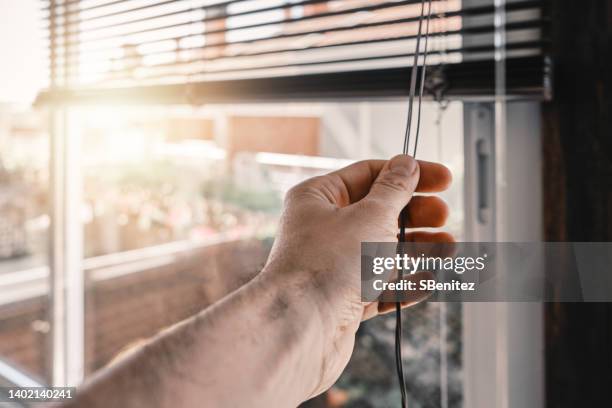 opening the roller blinds in the morning on sunny day - lameller bildbanksfoton och bilder
