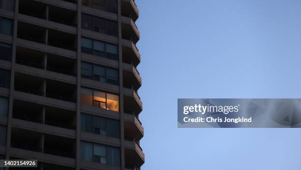 single light on in residential tower - single object stock pictures, royalty-free photos & images