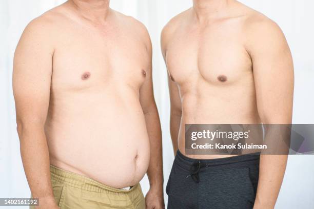 over weight men and muscular men - male body stockfoto's en -beelden