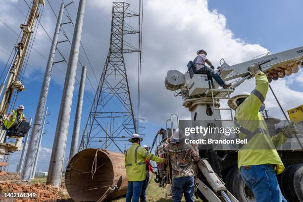 Service technicians work to install the foundation for a transmission tower at the CenterPoint Energy power plant on June 10, 2022 in Houston, Texas....