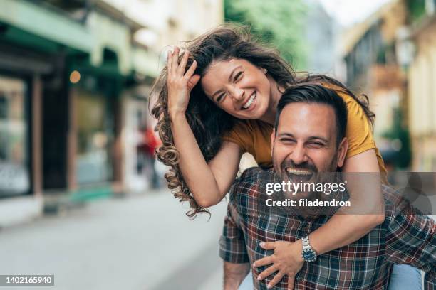 retrato de una pareja joven feliz al aire libre - pareja de mediana edad fotografías e imágenes de stock