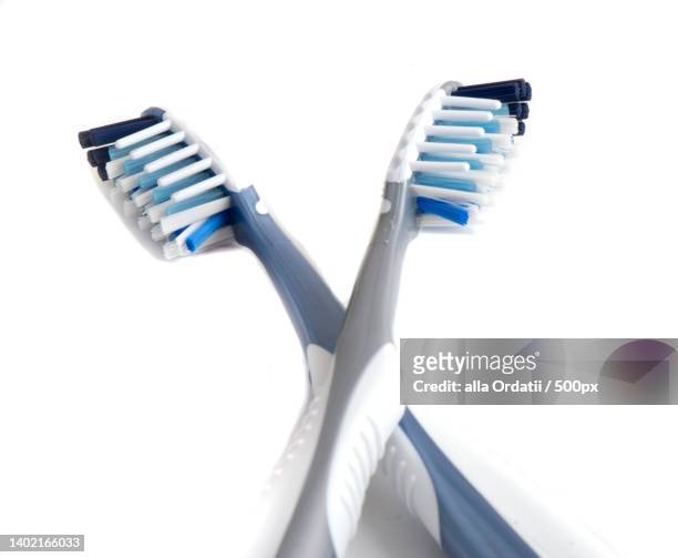 white plastic toothbrush closeup isolated on white - dentifrice stockfoto's en -beelden