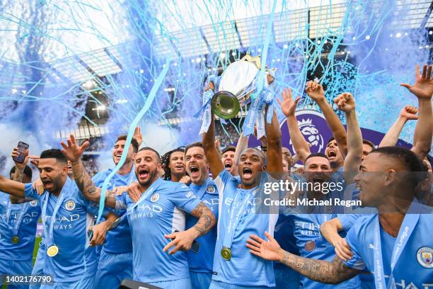 Fernandinho of Manchester City lifts the Premier League trophy with team mates Riyad Mahrez, Kyle Walker, Phil Foden, Kevin De Bruyne, Ruben Diaz and...