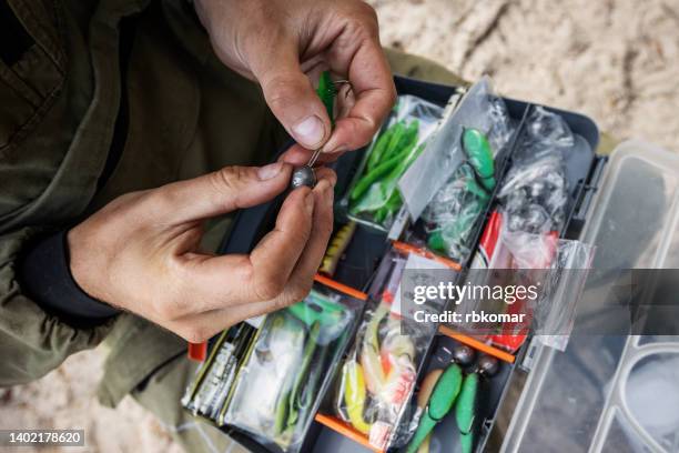 closeup of a fisherman putting on bait - fishing tackle box stock pictures, royalty-free photos & images