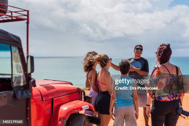 tourists listening to tour guide on the beach - tourist guide stock pictures, royalty-free photos & images