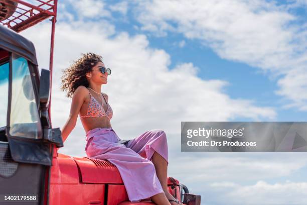 junger tourist, der vom offroad-auto aus den blick auf den strand blickt - lateinamerika stock-fotos und bilder