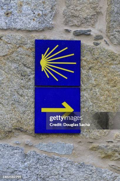 camino de santiago arrow and shell heading to compostela - santiago de compostela stock-fotos und bilder