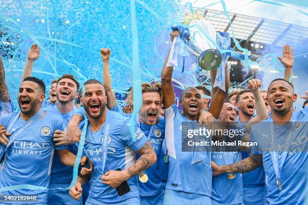 Fernandinho of Manchester City lifts the Premier League trophy with team mates Riyad Mahrez, Kyle Walker, Phil Foden, Jack Grealish Ruben Diaz and...