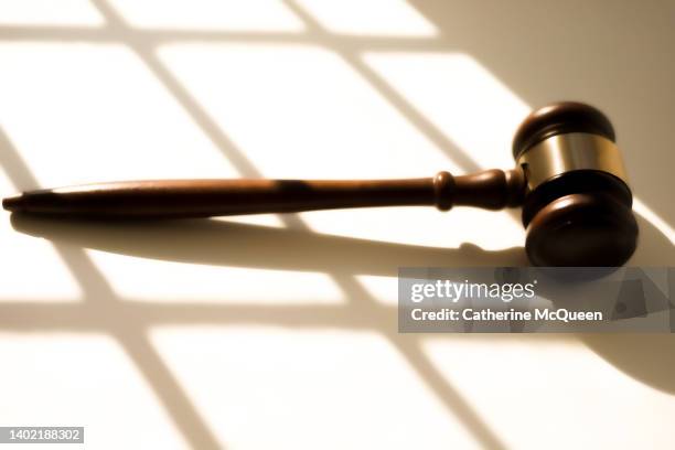 judge’s traditional wooden gavel on white background & shadow detail - sentencing fotografías e imágenes de stock