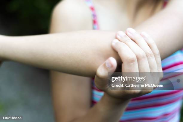 young mixed-race female stretching arm after workout - daily sport girls bildbanksfoton och bilder