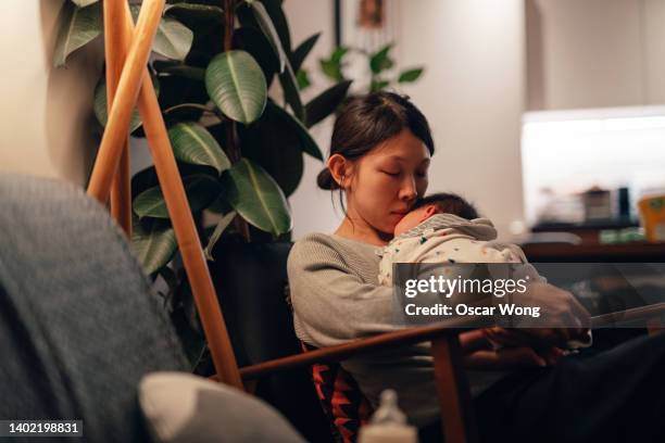 young mother feeling stressed and exhausted with a new baby - japanese baby photos et images de collection