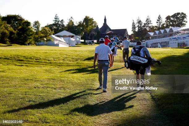 The group of John Merrick of the United States, Jim Knous of the United States, and Max Sekulic of Canada walks across the 18th hole during the...